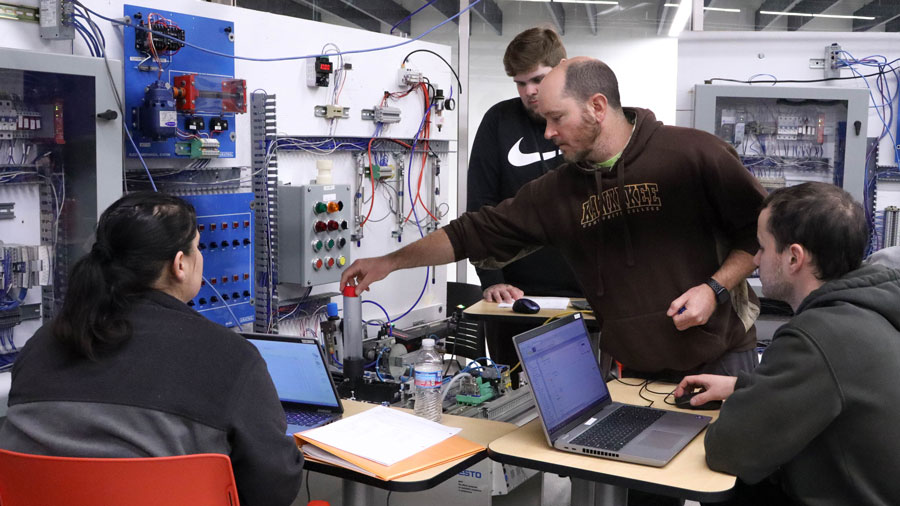 Professor Patrick Klette working with three students in an electrical engineering lab