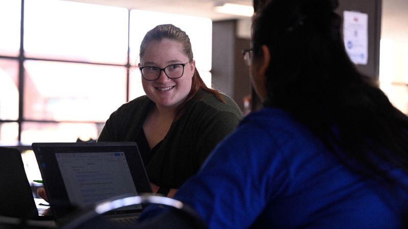 Students sitting at a table inside the college center at KCC.